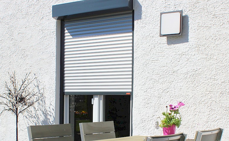 Terrace with chairs and front-mounted rolling shutters